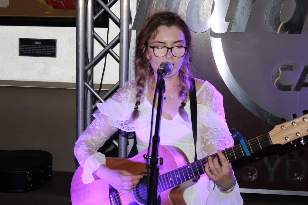 Aimée in a white lace dress at the Hard Rock Cafe, Sydney
